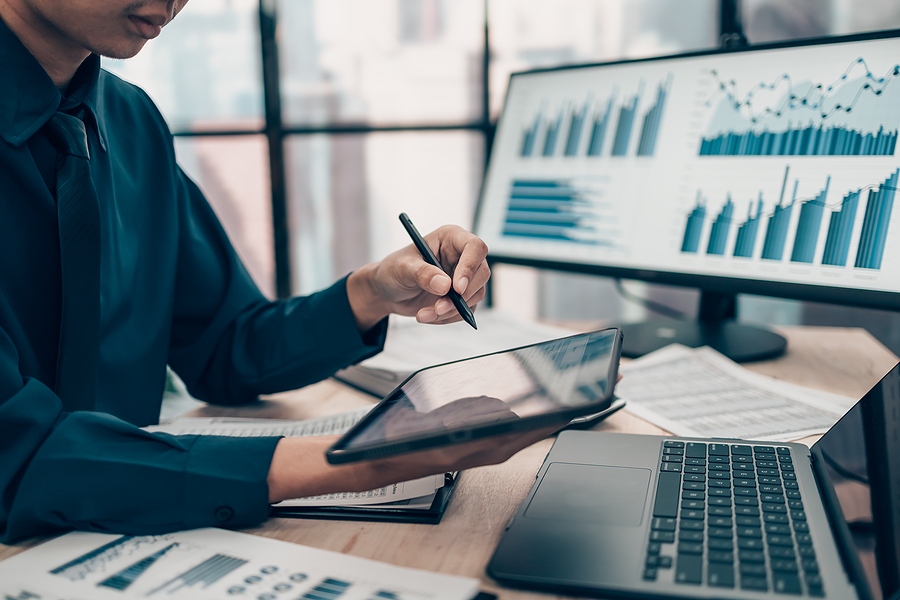 Job Costing strategies for multi-phase projects, Investors working on desk office and use tablet to check tracking cost. Accounting and Financial concept.